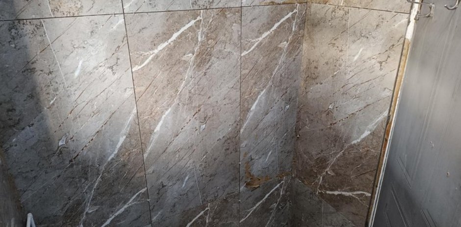 Bathroom corner after marble-look tiles were fitted