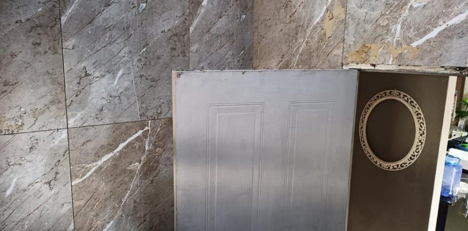 Door opening after marble-look tiles were fitted